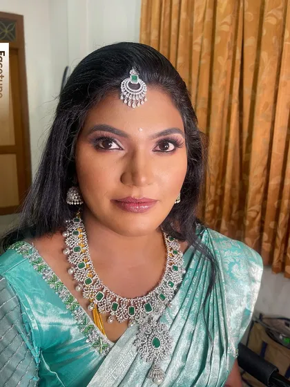 A portrait of Karthiga, showing her complete reception look. The glamorous makeup enhances her features and gives her a radiant glow, perfect for her dusky skin tone.