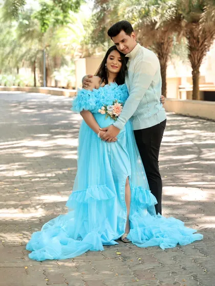 A beautiful outdoor portrait of a couple. The flowing blue gown looks ethereal against the natural backdrop of trees.