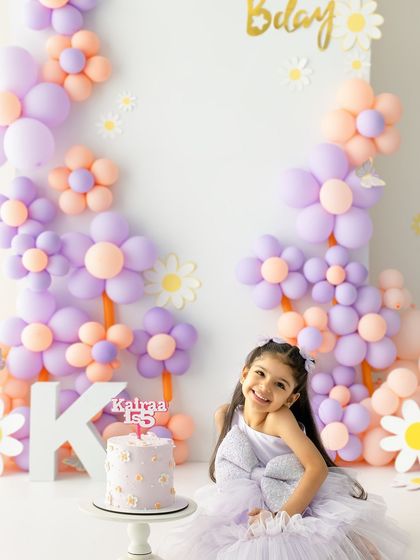 A happy smile next to her beautiful birthday cake. These milestone sessions are all about capturing the joy and excitement of growing up.