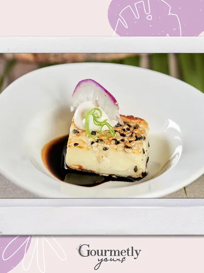 A single, artfully plated appetizer from our festive menu. This polaroid-style image of a tofu dish highlights the gourmet quality and attention to detail in every bite.