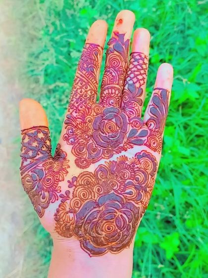 A beautiful, dense design with swirling rose patterns that cover the entire back of the hand.