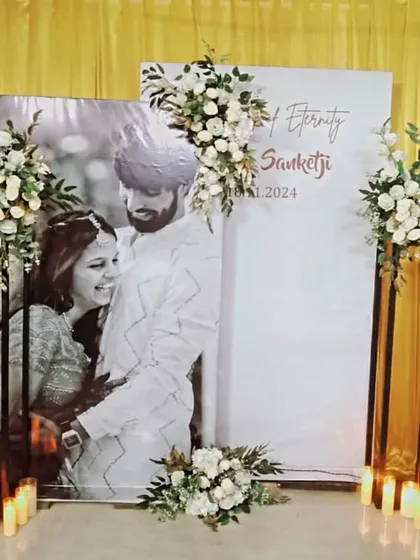 An elegant and timeless photo backdrop. The black and white portrait of the couple is complemented by classic white floral arrangements on black stands.