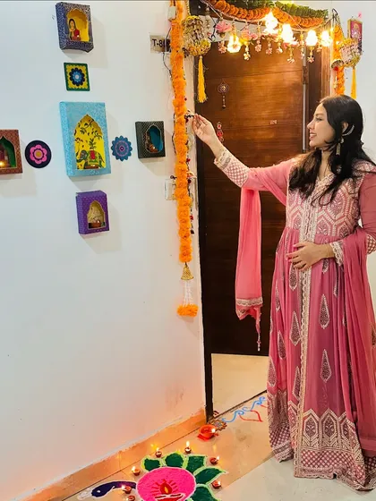 Adding the final touches to my home's Diwali decorations. The colorful wall art and traditional marigold garlands are simple ways to create a festive and welcoming entryway.