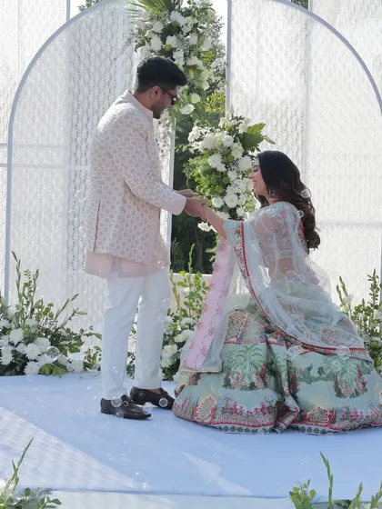 The bride gets down on one knee to put a ring on her groom, a sweet and modern twist on the tradition.