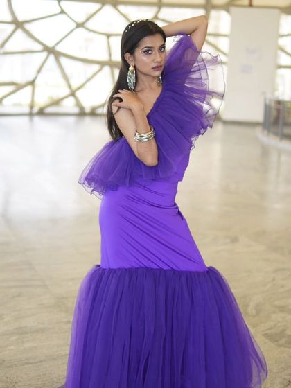 The makeup here was designed to be both bold and elegant. A defined eye and a perfectly glowing complexion ensure the model looks striking and confident, letting the designer's creation shine.