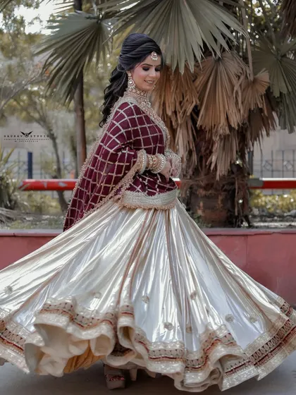 A beautiful twirling shot, capturing the full flare of the white lehenga against the contrasting maroon dupatta.