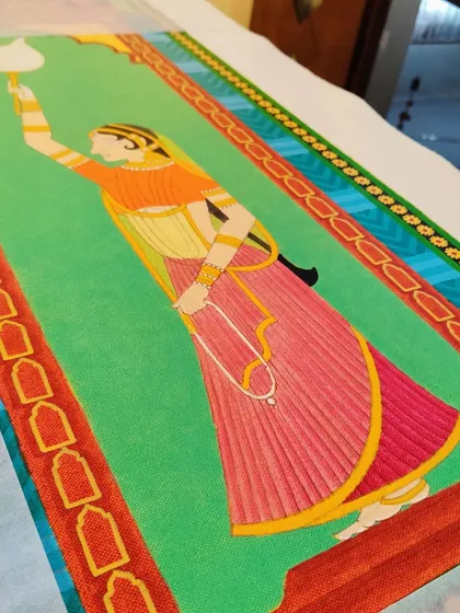 The painted Gopi attendant, showing her colorful dress and the lamp she holds.