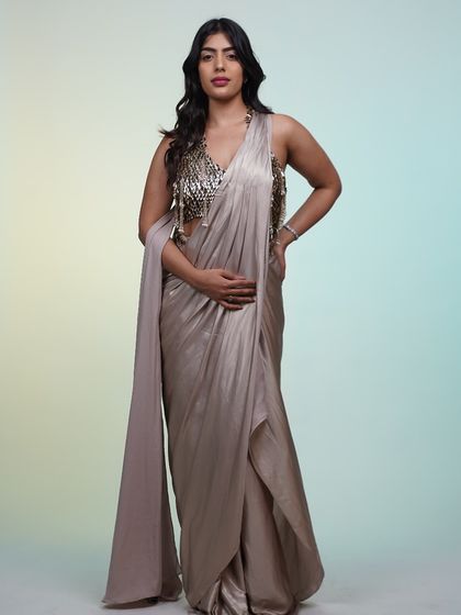 A full-length shot of the metallic pre-draped saree, showing off its unique silhouette and the stunning contrast of the embellished blouse.