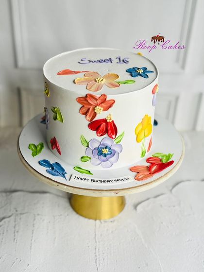 A floral dream for a sweet 16. This elegant cake is covered in colorful, hand-painted blooms using a palette knife technique, making it a true work of art.