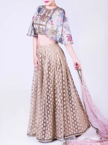 For a modern twist on festive wear, I designed this light organza lehenga set. It features a beautifully embroidered crop top with delicate floral patterns and contemporary cape sleeves, perfect for a sangeet or cocktail event.