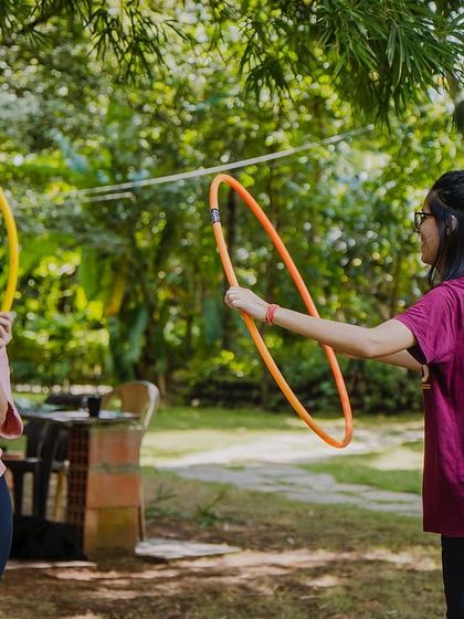 Two participants practicing together during a hoop dance workshop. The community aspect is huge; we all learn from and hype each other up.