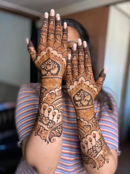 A playful pose from a happy client, showing off her gorgeous engagement mehendi.