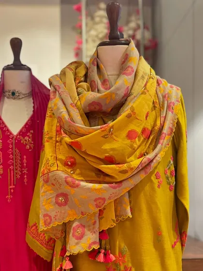 A close-up on the artfully draped floral dupatta, showcasing its beautiful print and how it complements the solid mustard kurta.