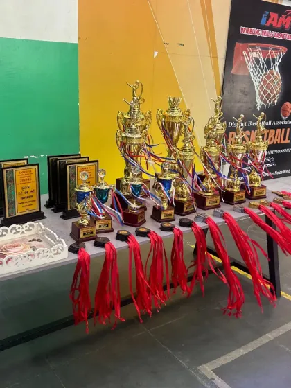 The spoils of victory. A table full of trophies and medals from the U-14 District Basketball Championship, a testament to our teams' hard work.