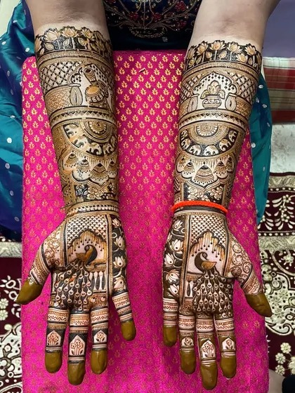 This bridal design is a celebration of traditional art. It features majestic peacocks on the palms and detailed work with elephants and lotuses on the arms, perfect for a bride who wants a classic and grand mehendi.