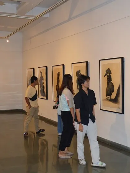 Visitors viewing the large-scale drawings from the 'Quieter than Silence' series.