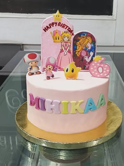 A Super Mario themed cake for Mihikaa's 6th birthday. This pink cake is decorated with Princess Peach, Toad, and other characters from the beloved game.