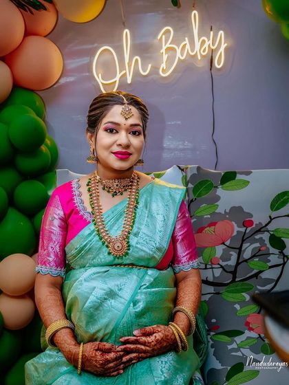A lovely seated portrait of the mother-to-be, looking calm and happy in front of the neon sign.