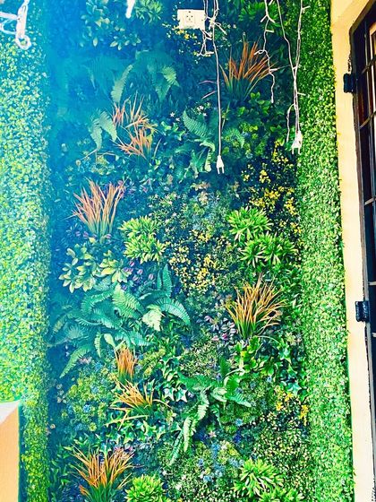 This design uses a mix of ferns and grasses with touches of yellow and purple. The subtle color variations add interest and a more natural feel to the indoor green wall.