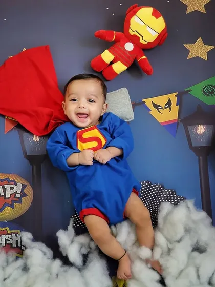 A happy little Superman flying high above the clouds. The joy on his face is absolutely infectious in this dynamic superhero-themed shot.