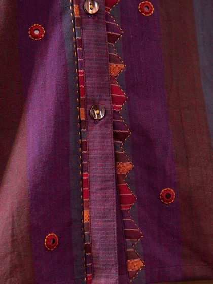A close-up of the placket of our Haveli Purple Striped Top. The combination of appliqué, mirror work, and hand embroidery creates a rich, textured detail.