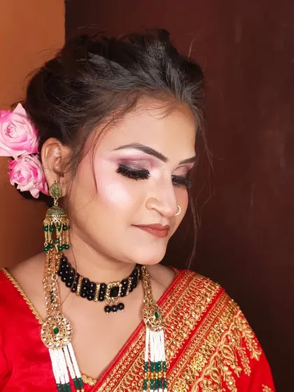 A close-up of the party makeup, showing the blend of pink and black eyeshadow and the fresh flowers in her hair.