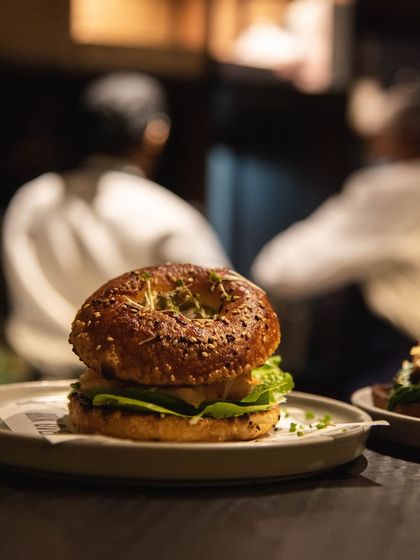 Our sourdough bagel sandwich, perfectly plated and ready to eat. The sesame seeds on the bagel add a nice texture and nutty flavor.