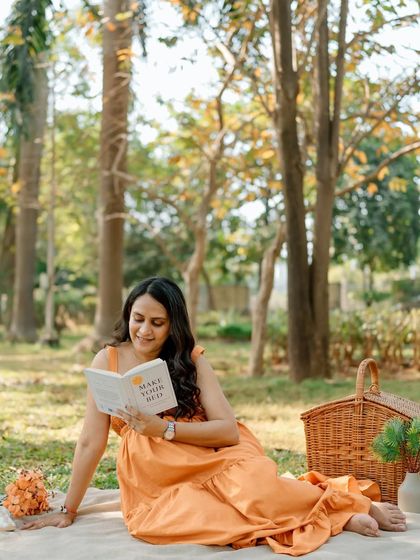 Enjoying a quiet moment to read during her sunny park picnic session. It's a beautiful way to capture her personality and the peace of this time.