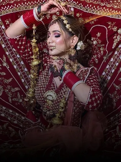 A dramatic shot of a bride in a classic red lehenga, with the skirt spread out to show the full embroidery.