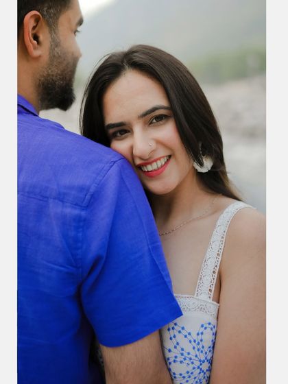 A close-up of the bride's happy and loving expression as she embraces her partner in the woods.