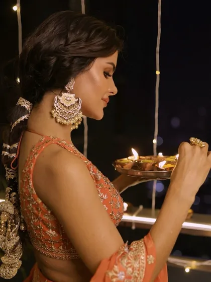 Glowing for Diwali. This look for Priyanka features a stunning orange lehenga, a traditional braided hairstyle, and warm, luminous makeup.