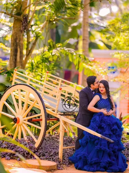 A romantic maternity moment by the rustic bullock cart prop.