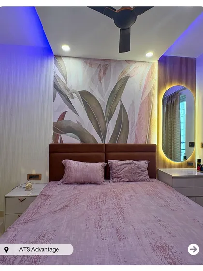 This bedroom uses a large, nature-inspired wallpaper as a stunning accent wall. The backlit oval mirror and simple nightstand create a chic and modern vanity corner.