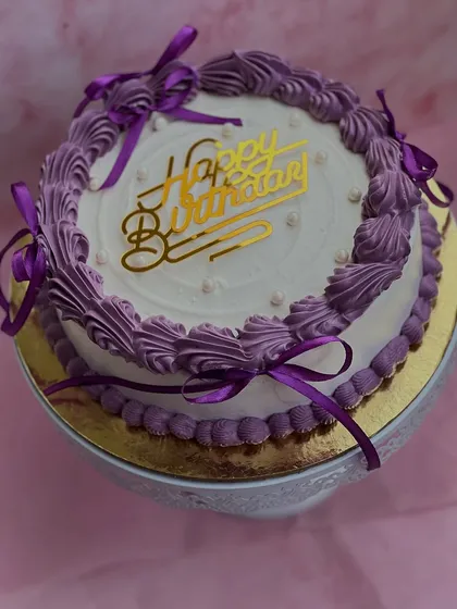 An overhead view of our purple vintage birthday cake, showing the intricate buttercream swirls and the "Happy Birthday" topper.
