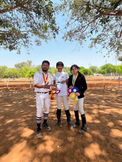 Our riders posing with their well-earned medals and ribbons under the shade of a tree. These are the moments that make all the hard work worthwhile.