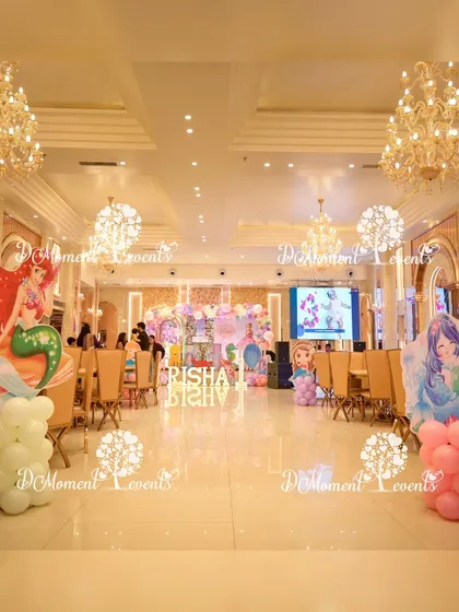 A wide view of the elegant banquet hall decorated for a mermaid party, with character cutouts and balloon pillars placed throughout the space.