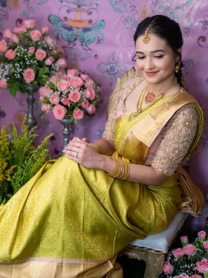 A full-length view of the bride in her lime green and pink saree. The custom blouse and traditional jewelry create a soft and elegant look for her ceremony.