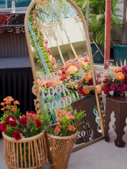 Another view of the selfie mirror, surrounded by flowers and reflecting the beautiful decor.