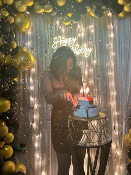 The moment of celebration! A client cuts her birthday cake, surrounded by a cascade of confetti in front of the black and gold decor I arranged.
