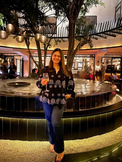 Enjoying a glass of wine at the newly opened Addoni's Delhi. This photo captures the beautiful ambiance of the restaurant's courtyard, perfect for a summer evening.