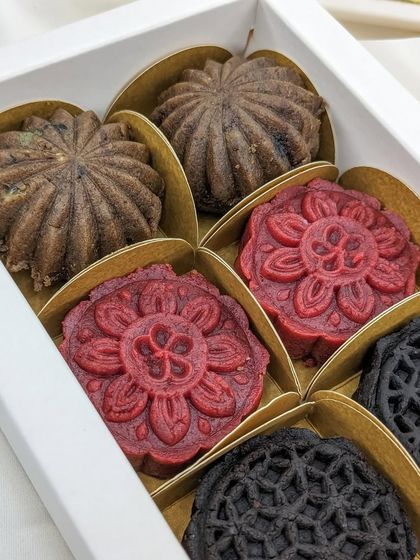 The complete assortment of our Christmas Cake Mithai, with intricate designs in festive colors of deep red, rich brown, and dark chocolate.