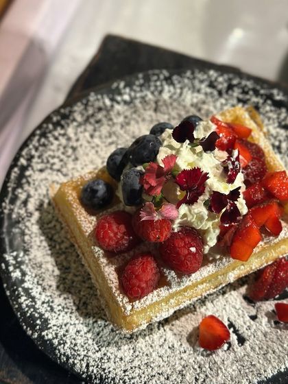 A light, crunchy waffle topped with a cloud of whipped cream and a colourful medley of fresh berries. It's the perfect indulgent treat.