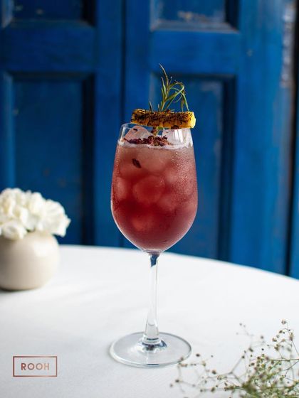 The Rose Merry cocktail, a perfect balance of sweet and aromatic flavours. The rosemary and rose petals create a delightful fragrance.