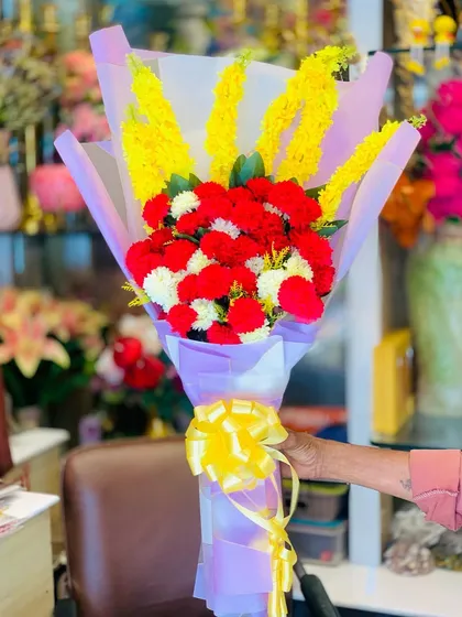 Another view of the artificial carnation and yellow flower bouquet, showing its vibrant colors from a different angle.