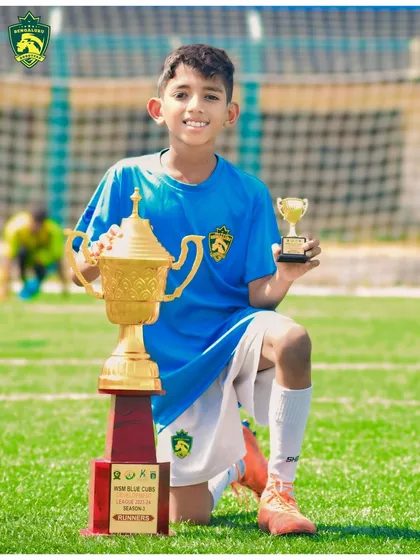 The joy of achievement. One of our young stars from the U-9 football team proudly displays his runners-up trophy from the WSM League 2024, a result of his hard work and our dedicated coaching.