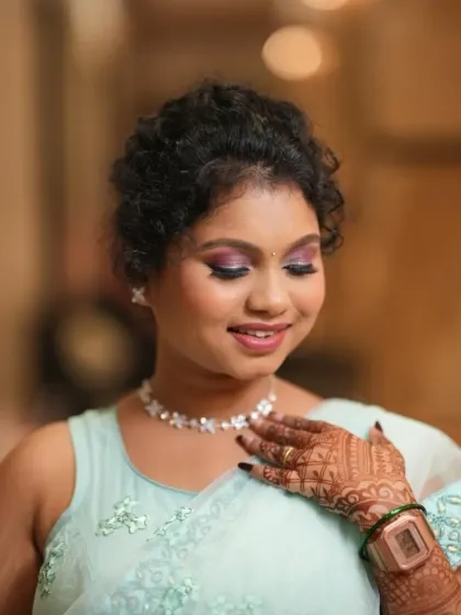 Embracing natural texture. For this bridesmaid with curly hair, we created a beautiful updo and paired it with a pop of color on the eyes for a fun and stylish look.