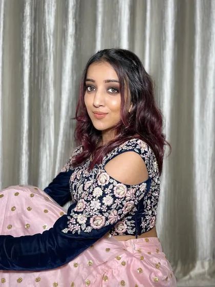 This look is too hot to handle. The intense black smokey eye is paired with a nude lip and soft beach waves, creating a stunning contrast with her pink and navy outfit.