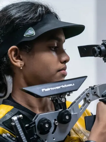 A close-up of a young athlete with her Feinwerkbau 800 rifle, demonstrating the intense focus cultivated during our daily training sessions.