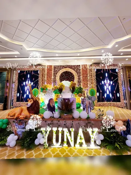 A full stage view of the luxurious jungle party, highlighting the marquee letters, large 3D animals, and the elaborate floral and LED screen backdrop.
