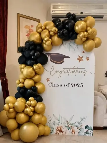 This setup is perfect for celebrating academic achievements, like for a graduation or a company intern's farewell. It features a custom printed backdrop for the "Class of 2025" framed by a classic black and gold balloon arrangement.